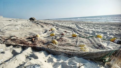 Fishing net on beach against sky