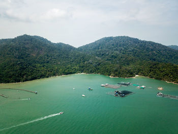 High angle view of sea and mountains against sky