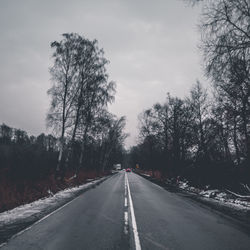 Road amidst trees against sky