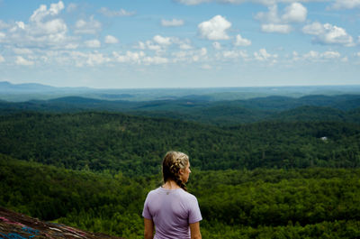 Rear view of woman standing on landscape against sky