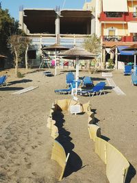 Chairs on beach against buildings in city