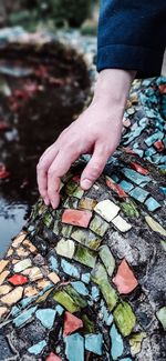 High angle view of person hand on rock