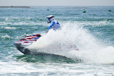 Man surfing in sea against sky