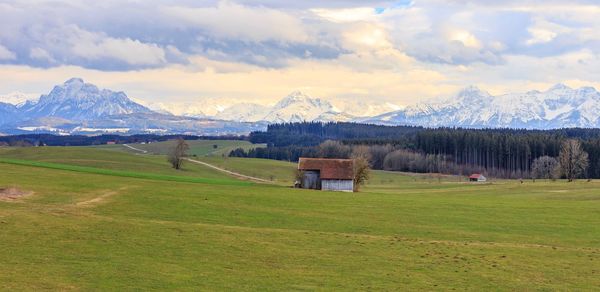 Scenic view of field and mountains against sky