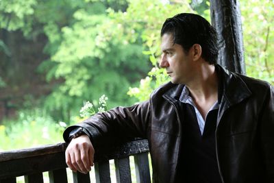 Man looking away while sitting on bench