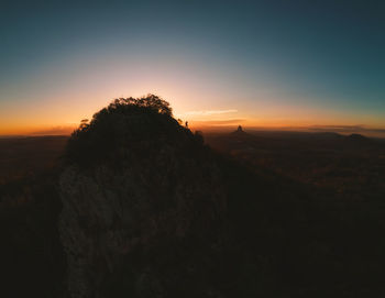 Rock formations on landscape against sky during sunset