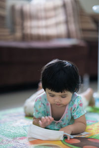 Full length of girl with book on table