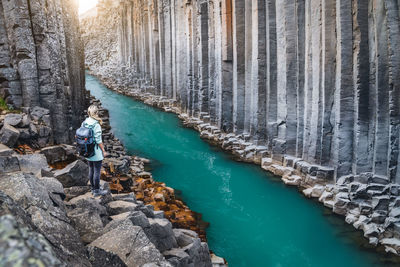 Woman standing on rock by water