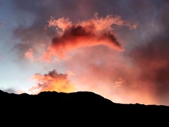 Low angle view of silhouette mountain against dramatic sky