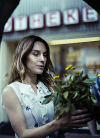 Female florist with yellow flowers at store