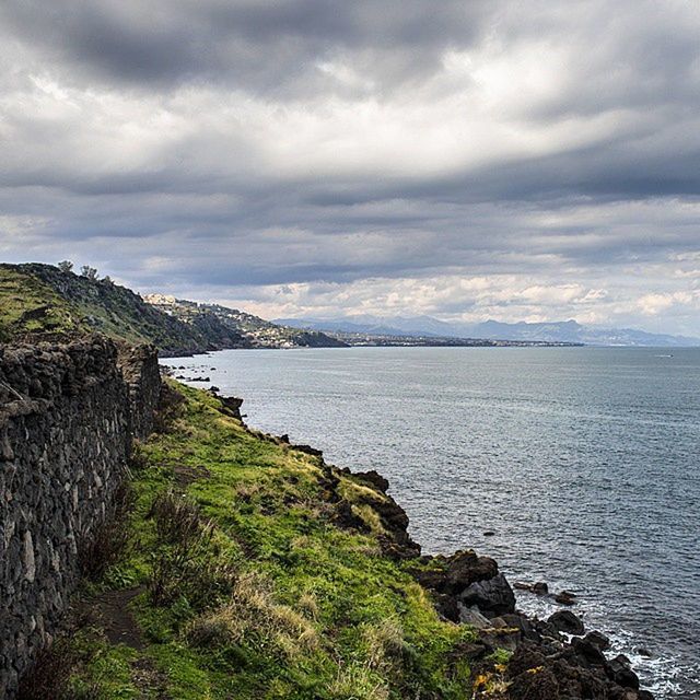 sky, water, tranquil scene, tranquility, scenics, cloud - sky, beauty in nature, cloudy, sea, nature, mountain, cloud, rock - object, idyllic, non-urban scene, landscape, day, remote, outdoors, overcast