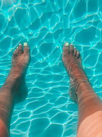 Low section of person swimming in pool