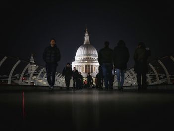 People walking in illuminated city at night