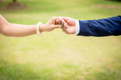 Midsection of couple holding hands