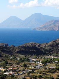 High angle view of townscape by sea against sky