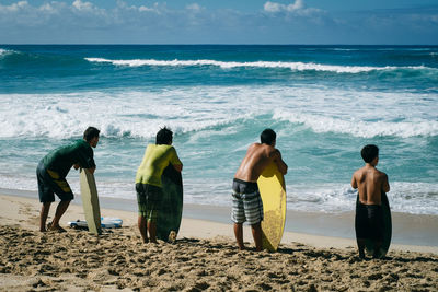 Rear view of people walking on beach