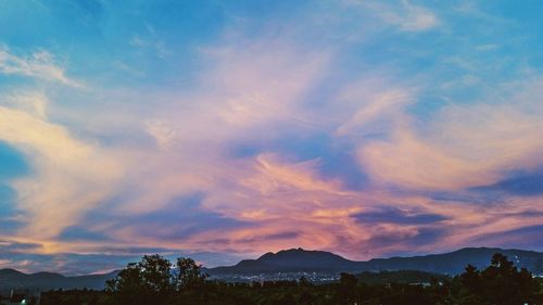 Scenic view of silhouette mountains against dramatic sky