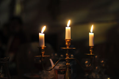 Close-up of lit candle in dark room