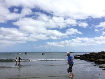 Rear view of a boy standing on beach