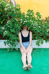 Thoughtful woman sitting alone outdoors. young worried in backyard