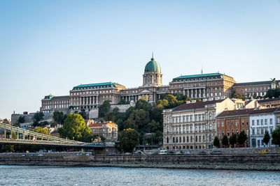 Bridge over river by buildings in city