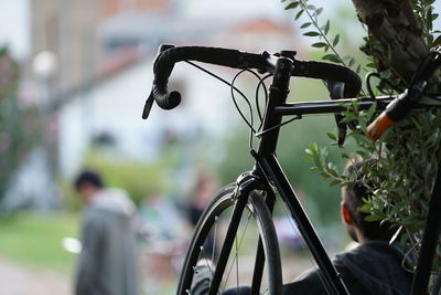 Cropped image of bicycle with men in background at park