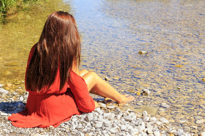 Rear view of woman sitting on beach