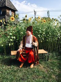 Full length of girl sitting on chair in field