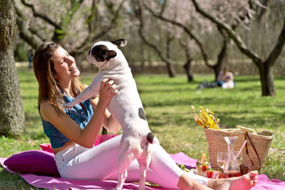 Portrait of woman with dog on field