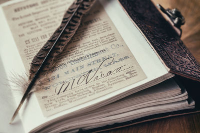 Vintage notebook with a feather pen on it. closeup.