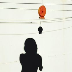 Low angle view of silhouette girl hanging on cable