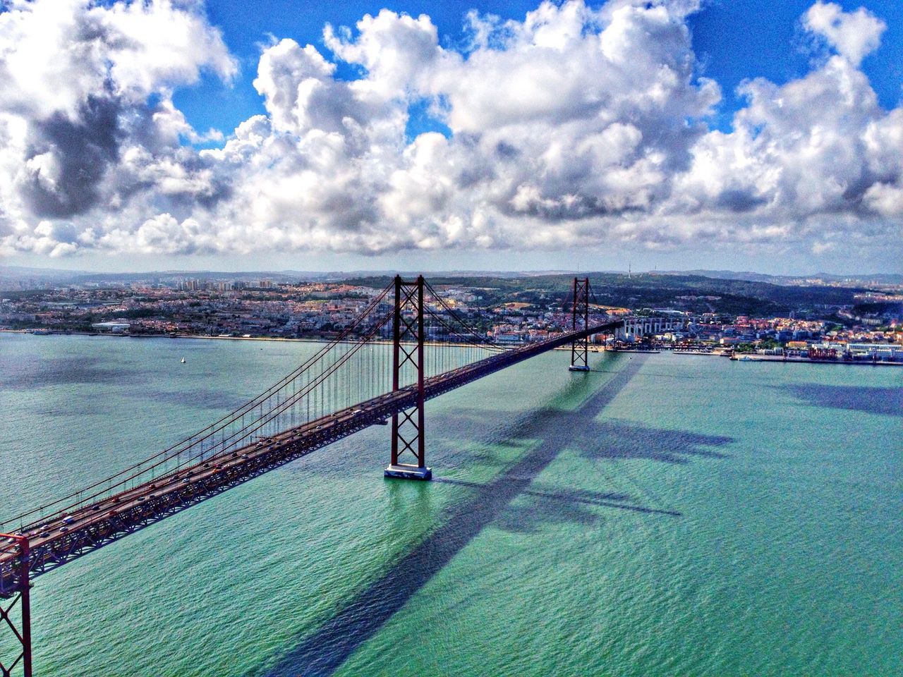 sea, water, sky, connection, built structure, architecture, blue, cloud - sky, suspension bridge, cloud, engineering, bridge - man made structure, transportation, horizon over water, cloudy, travel destinations, pier, day, nature, travel