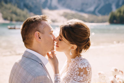 Couple embracing while standing at riverbank