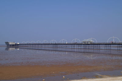 Bridge over sea against clear sky