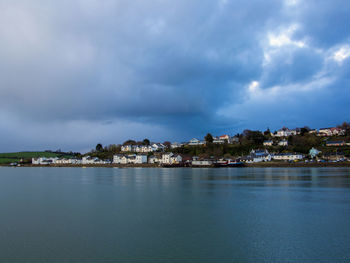 Scenic view of sea by buildings against sky