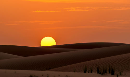 Scenic view of desert against sky during sunset