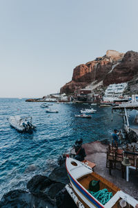 Boats in sea against clear sky