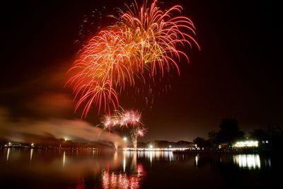 Firework display over lake at night