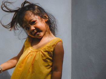 Portrait of smiling girl against wall