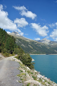 Scenic view of road by mountain against sky