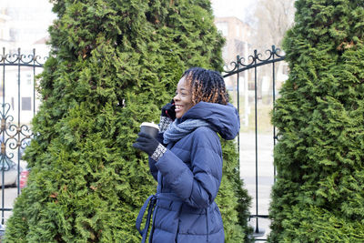 Woman standing by plants during winter