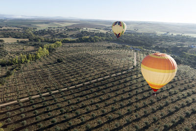 Hot air balloon flying over land against sky