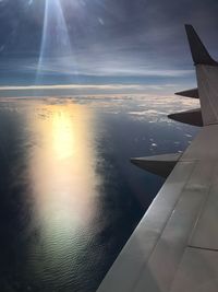 Scenic view of airplane wing over sea against sky