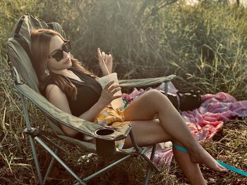 Young woman lying down while sitting on grass