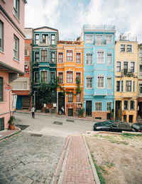 Residential buildings by street against sky