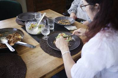 High angle view of woman eating meal at dining table