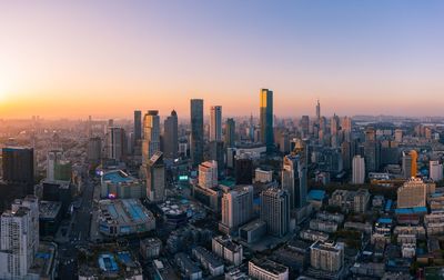 Aerial view of modern buildings in city against sky during sunset