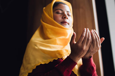 Low angle view of young woman praying