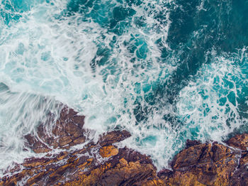 Full frame shot of waves breaking on rocks