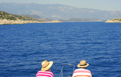 High angle view of men sitting against sea